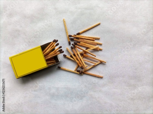 Detail closeup of the matchstick pile texture and matchbox design. A scattered pile of wooden matchsticks on an isolated white shabby paper background. photo