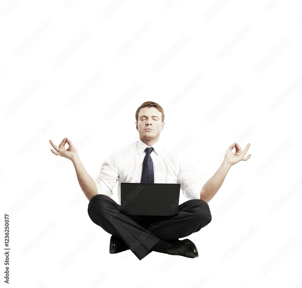 Businessman in formal attire sitting cross-legged in a meditative pose, holding a laptop on his lap, isolated on a clean white background