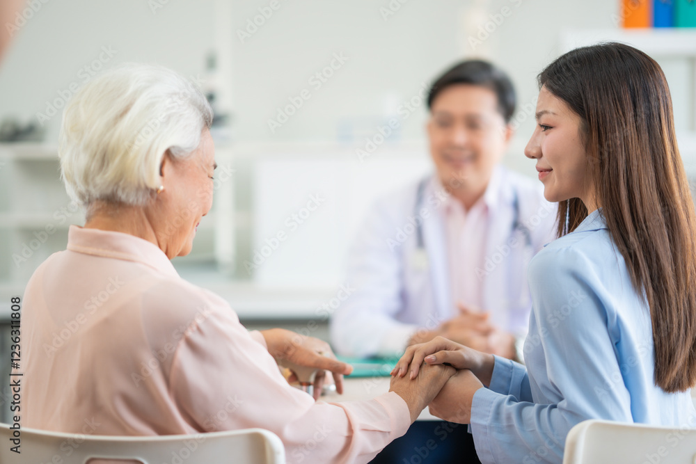 Fototapeta premium Asian male doctor give health advise to young woman and old woman at hospital kindness and warm. Young asian beautiful woman holds her mum hand give encouragement .