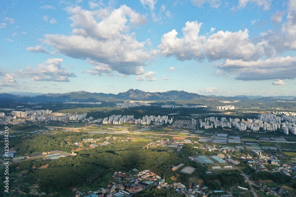 Fototapeta premium 북한산과 덕양구 화정동의 조화: 자연과 도시의 만남 | Harmony of Bukhansan Mountain and Hwajeong-dong, Deogyang-gu: Where Nature Meets the City