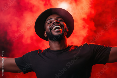 Portrait of single isolated young african hipster guy dancing in trendy hat and black t-shirt in nightclub over red smoky background