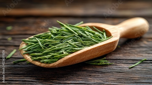 Fresh green tea leaves in wooden scoop on rustic table photo