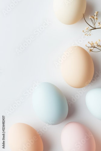 Pastel-colored Easter eggs rest on a clean white surface among delicate floral accents, creating an inviting and festive atmosphere for spring