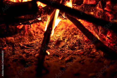 Burning firewood close-up bright flames orange and yellow colors intense heat glowing embers dark background suitable for fireplace campfire or bonfire themes