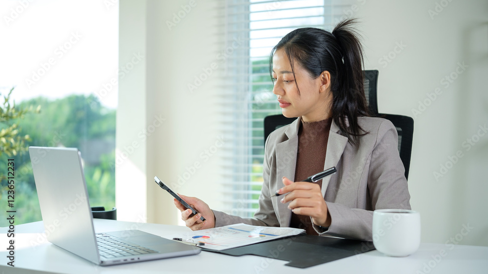 Business executive using mobile phone while reviews documents at desk. Business executive using mobile phone while reviews documents at desk.