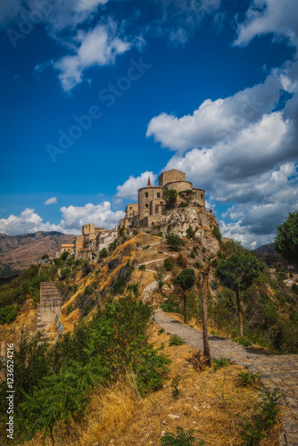 View of the church of S. Maria di Loreto in Petralia Soprana, Sicily, Italy. An avenue of trees leading to the hilltop village of Petralia Soprana in the Madonie Mountains. Long exposure. August 2024