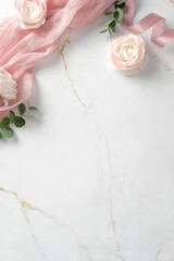 Elegant flat lay with pink ranunculus flowers, eucalyptus leaves, and a pink ribbon on a white marble background. Perfect for wedding invitations, feminine designs, and romantic themes
