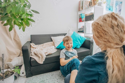 professional therapist teaching hand coordination exercises to young boy, therapeutic session at home, concept of sensory integration and child psychology photo