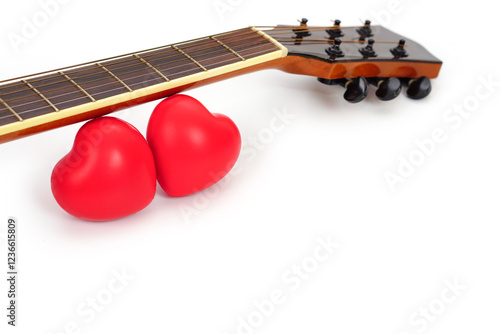 Acoustic guitar neck and red heart against white background. Love and music concept.