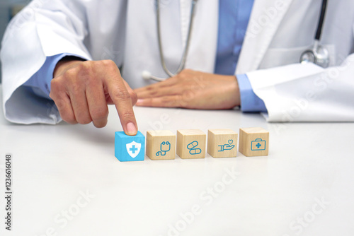 Finger of doctor touching a wooden block cube with medical icon symbol. Medical, health and insurance concept.