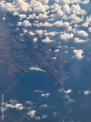 Aerial views form a plane looking through the clouds onto dramatic coastline. 