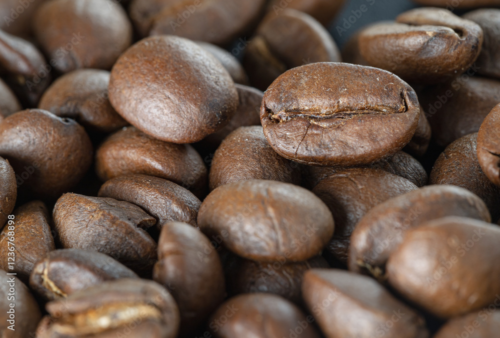 Close-up view of Roasted coffee beans on a rich textured surface. Enjoy your morning coffee for living, use it as your Space for text, Design, Wallpaper and Poster, Selective focus.