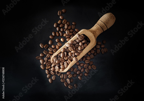 Obraz na płótnie Top view of Roasted coffee beans on a rich textured surface in Wooden coffee scoop on dark background. Enjoy your morning coffee for living, use it as your Space for text, Design, Wallpaper and Poster w salonie