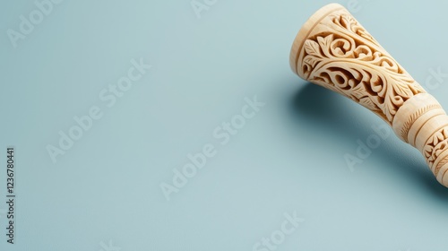 Bone Traditional Handmade Concept, Intricately Carved Bone Whistle with Natural Motifs on a Soft Blue Background photo