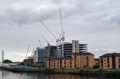 View of Riverside Apartments and  Buildings under Construction Reflected in Water on Cloudy Day 
