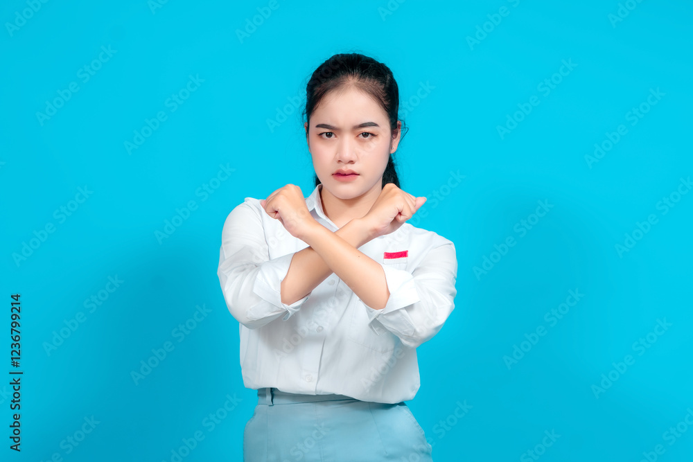 female student dressed in a uniform gesturing Stop with Hand on a Blue Background female student dressed in a uniform gesturing Stop with Hand on a Blue Background