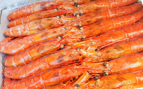 Large frozen langoustines in a package on the counter of a fish market, close-up photo