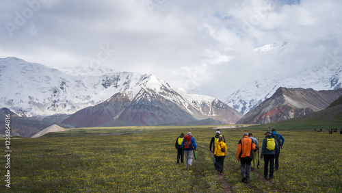 Wallpaper Mural Group of tourists hiking in green alpine valley towards snowy peaks in Pamir Mountains, Kyrgyzstan Torontodigital.ca