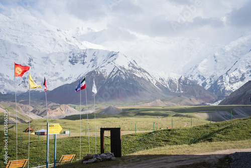 International flags flapping expedition camp with snowy Pamir Mountains in backdrop, Kyrgyzstan photo