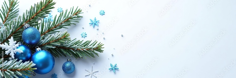 Fototapeta premium Frosted pine branch with snowflakes and blue ornaments on a white background, winter scene, festive