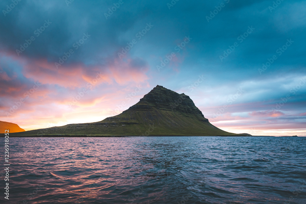 Kirkjufell mountain on the Snaefellsnes peninsula in Iceland during sunset. The iconic peak reflects over the calm waters, surrounded by vibrant colors of the evening sky Kirkjufell mountain on the Snaefellsnes peninsula in Iceland during sunset. The iconic peak reflects over the calm waters, surrounded by vibrant colors of the evening sky