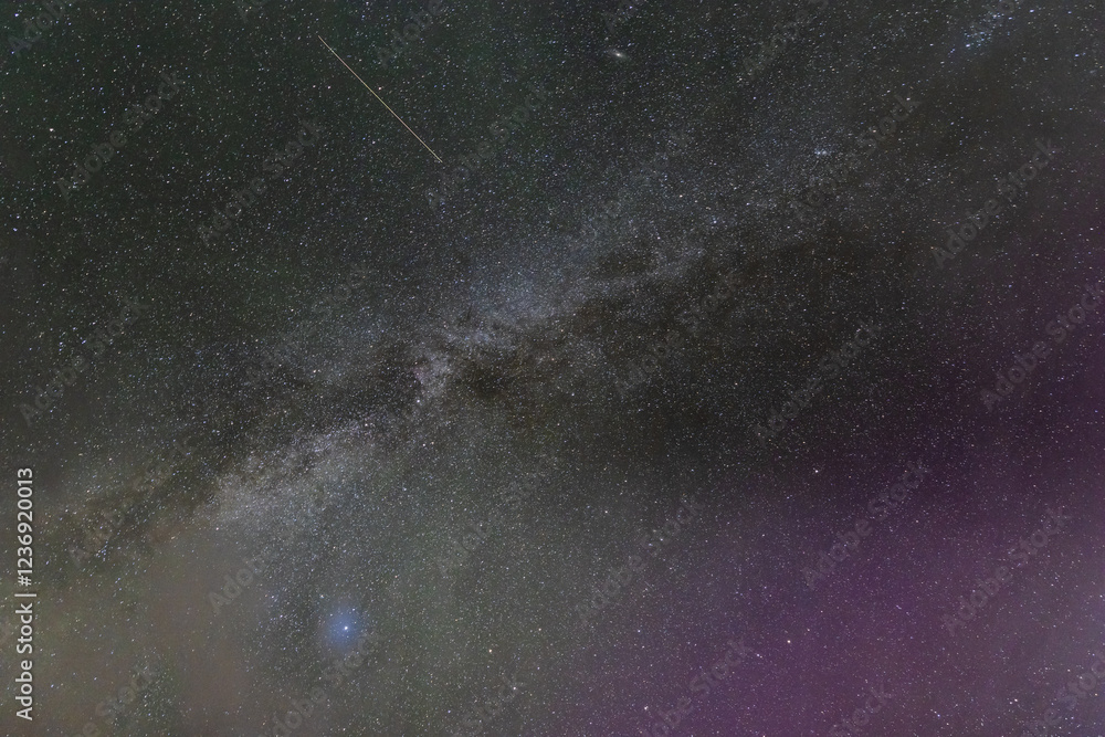 Obraz premium Mesmerizing view of the Milky Way galaxy stretches across the night sky, dotted with countless stars and a visible shooting star. Icelandic night sky. Snaefellsnes peninsula