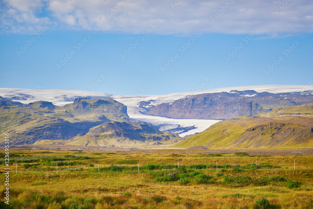 Beautiful nature landscape with green fields and majestic cliffs with ice and snow in Southern Iceland. Beautiful nature landscape with green fields and majestic cliffs with ice and snow in Southern Iceland.