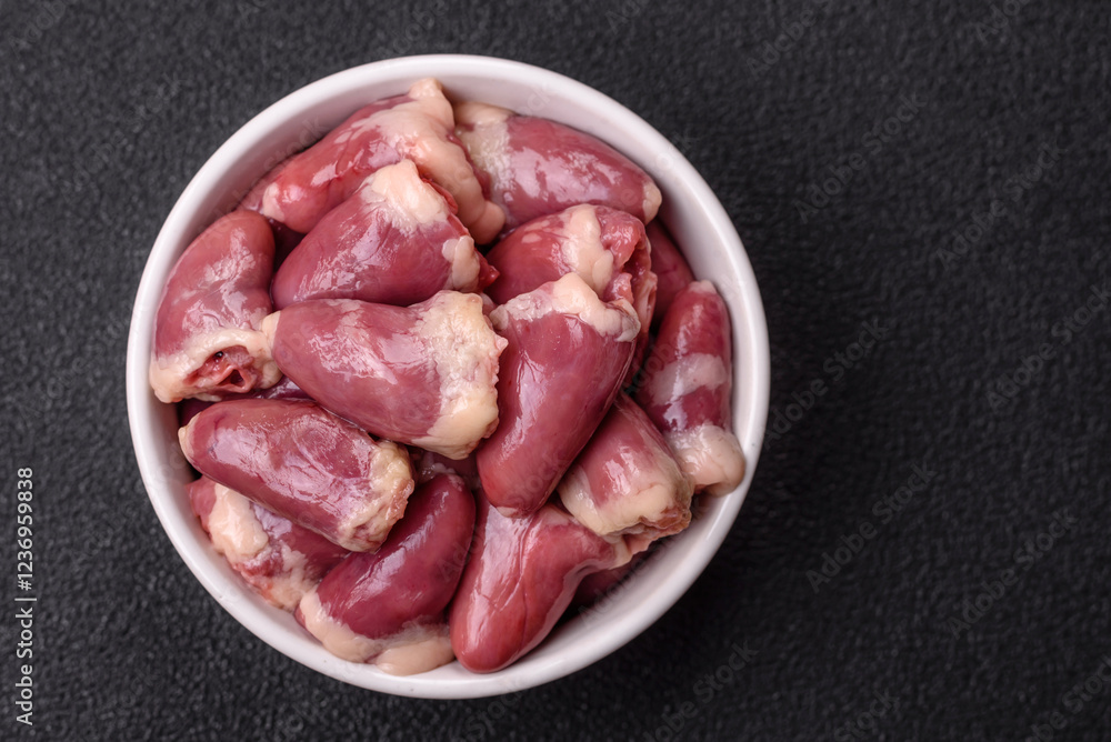 Raw chicken hearts with salt, spices and herbs Raw chicken hearts with salt, spices and herbs