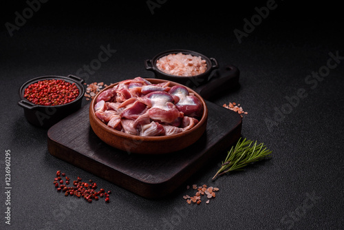 Raw chicken or turkey gizzards with salt, spices and herbs photo