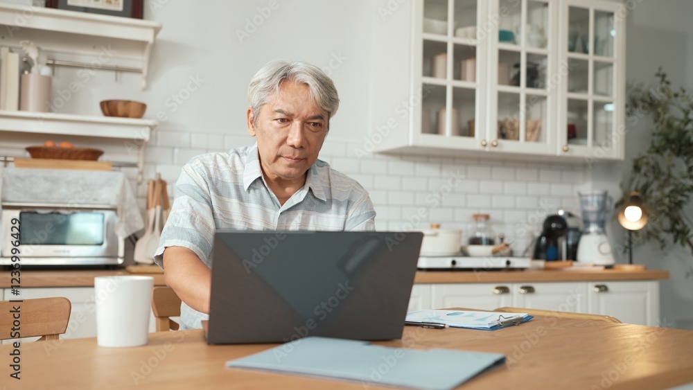 Senior man with casual cloth working on laptop while sitting at home. Elder businessman writing report and looking at financial data while making decision for investment in start up project. Myrmidon. Senior man with casual cloth working on laptop while sitting at home. Elder businessman writing report and looking at financial data while making decision for investment in start up project. Myrmidon.
