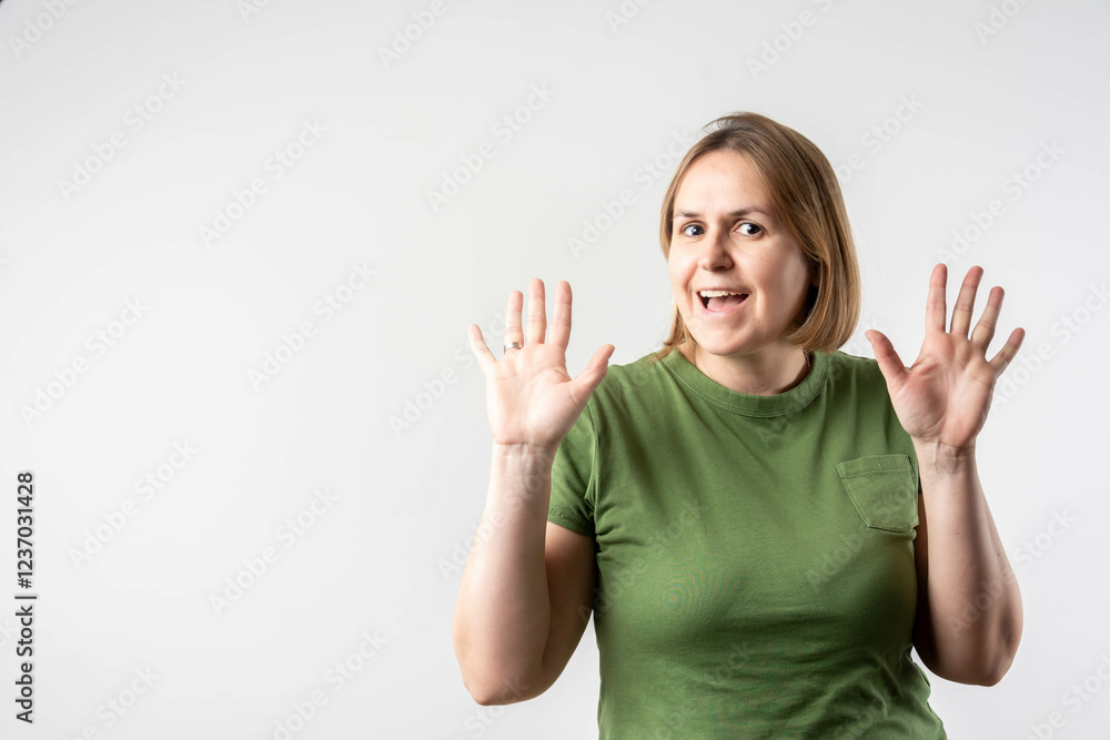 Joyful mature woman girl in green t-shirt posing isolated on grey background studio portrait. People lifestyle concept. Mock up copy space. Beautiful woman, doing winner gesture. Joyful mature woman girl in green t-shirt posing isolated on grey background studio portrait. People lifestyle concept. Mock up copy space. Beautiful woman, doing winner gesture.
