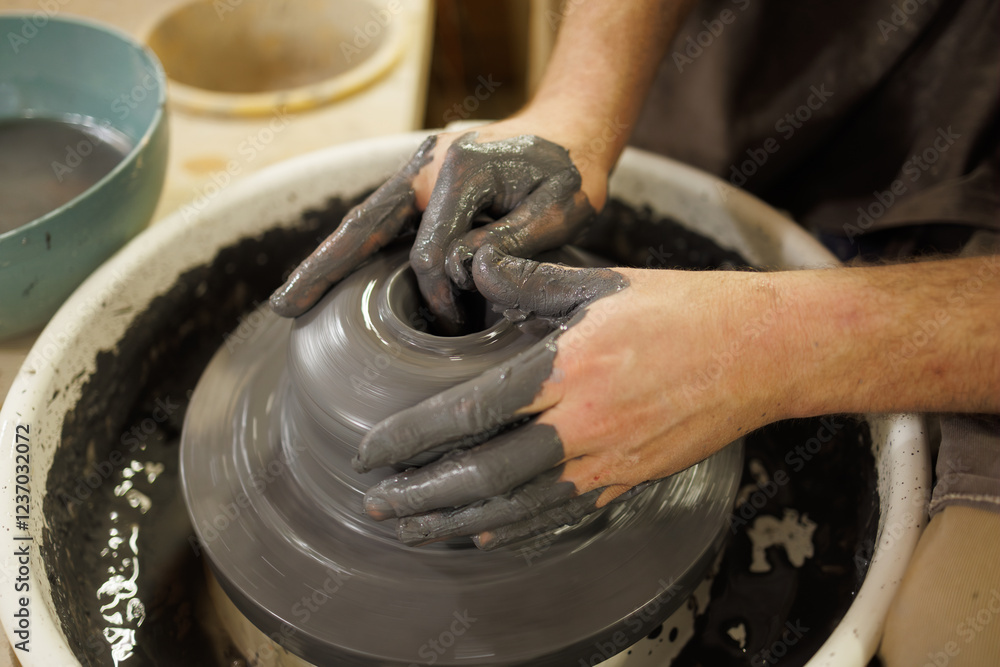 Part of craftsman shaping clay on pottery wheel in studio Part of craftsman shaping clay on pottery wheel in studio