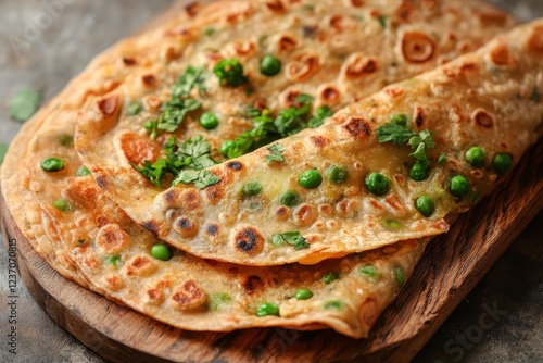 Aloo Mutter a dry Indian dish of spiced potatoes and green peas garnished with coriander and served with roti or chapati photo