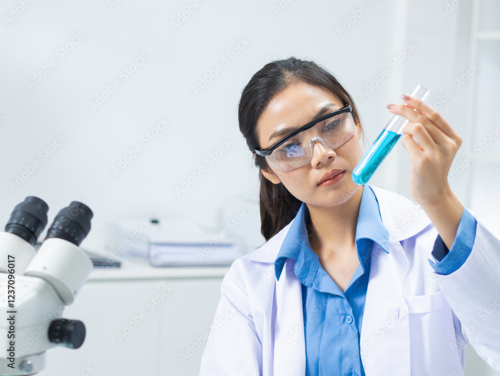 Professional Young Asian female scientist using test tube in a laboratory, analyzing liquid samples in a modern lab. Asian woman researcher focuses on liquid analysis using tablet record a data. Professional Young Asian female scientist using test tube in a laboratory, analyzing liquid samples in a modern lab. Asian woman researcher focuses on liquid analysis using tablet record a data.