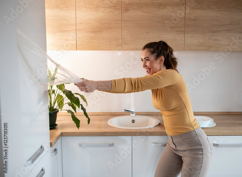 Woman removing foil from brand new kitchen cabinets photo