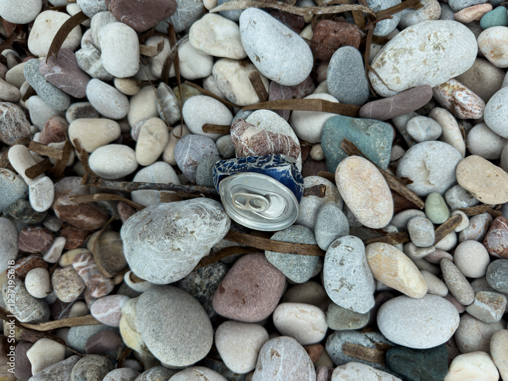 Crushed Aluminum Can Washed Ashore on Pebble Beach During a Storm Crushed Aluminum Can Washed Ashore on Pebble Beach During a Storm