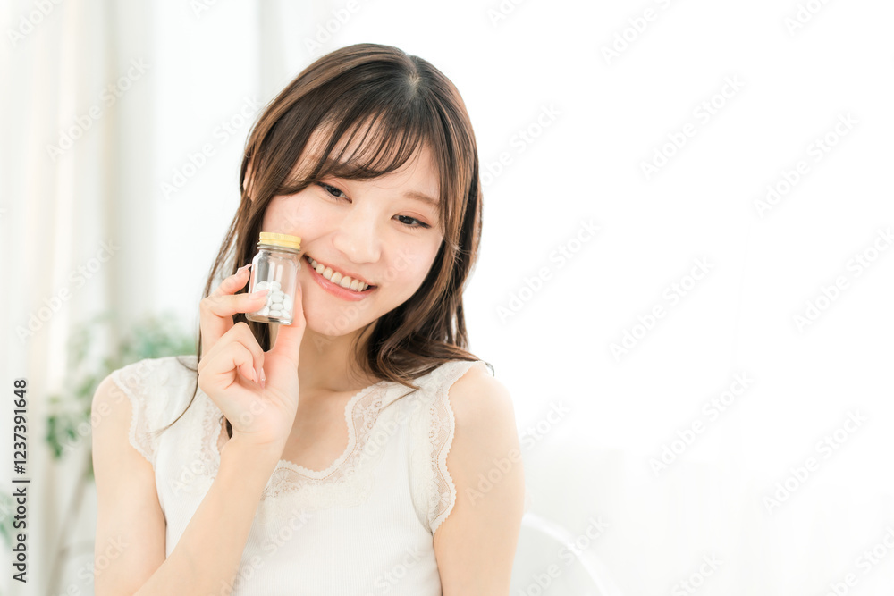 薬・サプリメントの瓶を持つ笑顔のアジア人女性
薬・サプリメントの瓶を持つ笑顔のアジア人女性