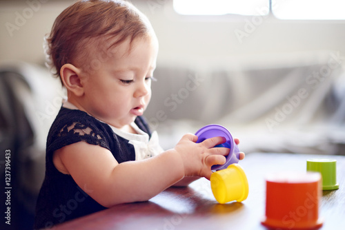 Home, baby and child with toys for development, playing and motor skills for stack. House, girl and childhood with plastic cups for sensory interaction, learning or cognitive growth with curious game
