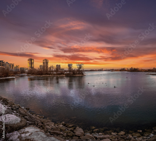 Wallpaper Mural Fiery sunset over a calm lake, city skyline in the distance. Torontodigital.ca