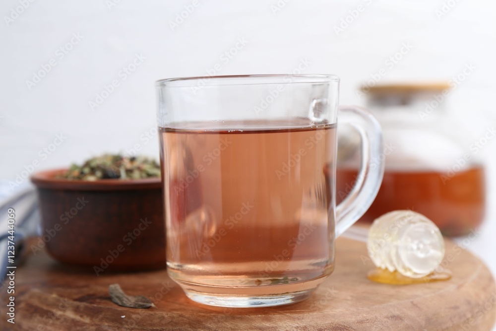 Delicious herbal tea, honey and dry leaves on white table, closeup Delicious herbal tea, honey and dry leaves on white table, closeup