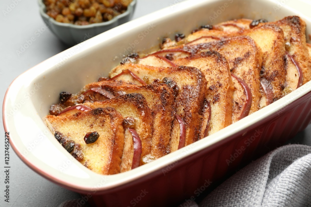Delicious bread pudding in baking dish on light gray table, closeup Delicious bread pudding in baking dish on light gray table, closeup