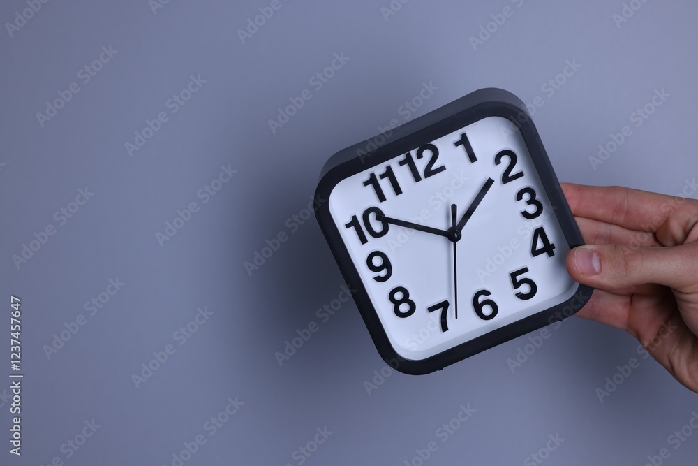 Man with alarm clock on grey background, closeup. Space for text Man with alarm clock on grey background, closeup. Space for text
