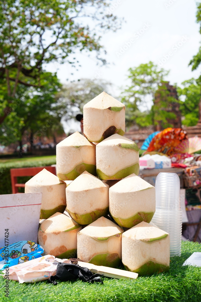 Fototapeta premium Young coconuts for sale in front of Wat Mahathat, Ayutthaya Province, Thailand. Photographed on March 29, 2024.