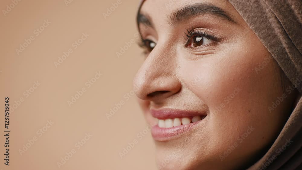 A young Arab woman in a hijab displays a warm smile, highlighting her features. The studio background is neutral, creating a serene and inviting atmosphere for the portrait. A young Arab woman in a hijab displays a warm smile, highlighting her features. The studio background is neutral, creating a serene and inviting atmosphere for the portrait.