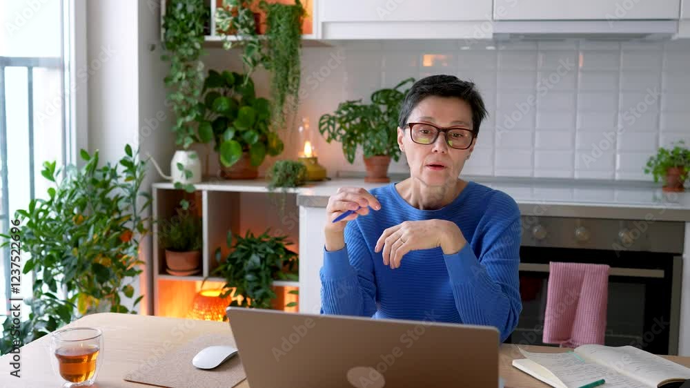 Fatigued mature woman removes glasses, massages eyes after completing working tasks on laptop at home. Exhausted female struggles with migraines, dry eyes, isolation and demands of remote work Fatigued mature woman removes glasses, massages eyes after completing working tasks on laptop at home. Exhausted female struggles with migraines, dry eyes, isolation and demands of remote work