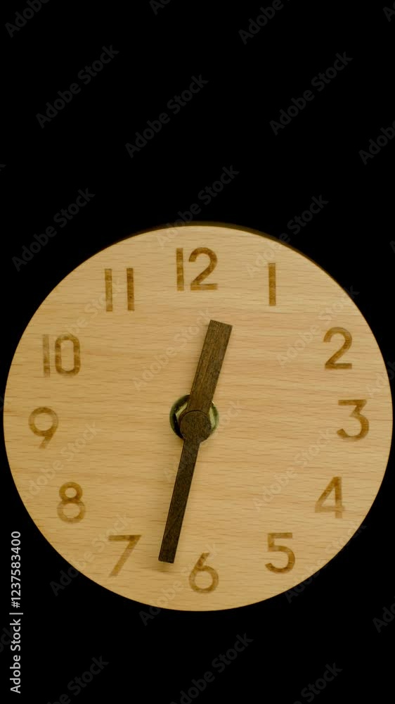 Vertical time lapse video of a wooden clock time passing over a day to night on black background.