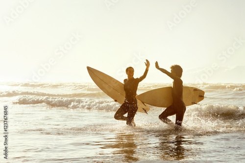 Sticker Surfing friends, high five and beach in water with celebration, congratulations and fitness achievement in sunset