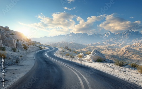 Scenic winding road through mountainous terrain under a clear blue sky at sunset
