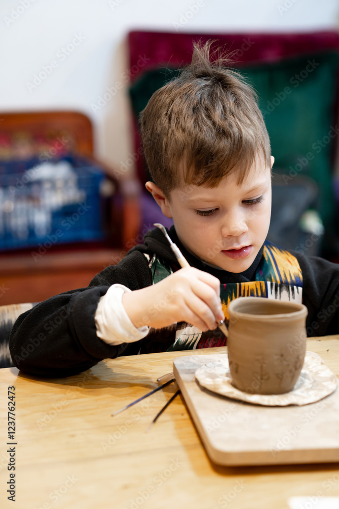 A boy creates a pot and decorating in a pottery workshop A boy creates a pot and decorating in a pottery workshop