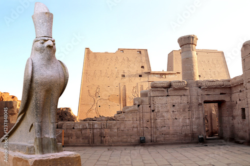 Tableau sur toile Granite statue of God Horus falcon at entrance Temple of Horus in sunset light, Edfu, Egypt